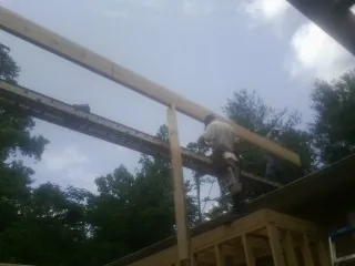 Carpenter setting a ridge beam over a new addition frame — Ice Dam Removal by Roofing Brothers in Christiansburg